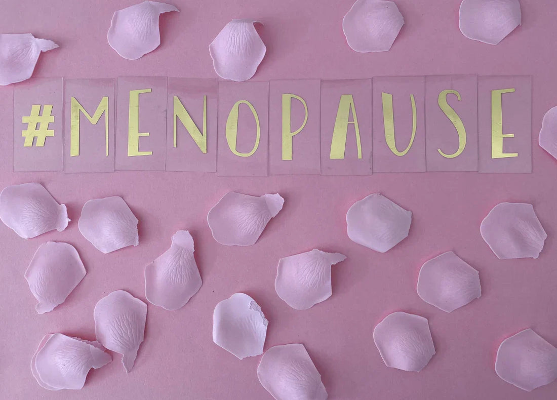 Image with pink background with a pink flower petals and also there are Menopause writing