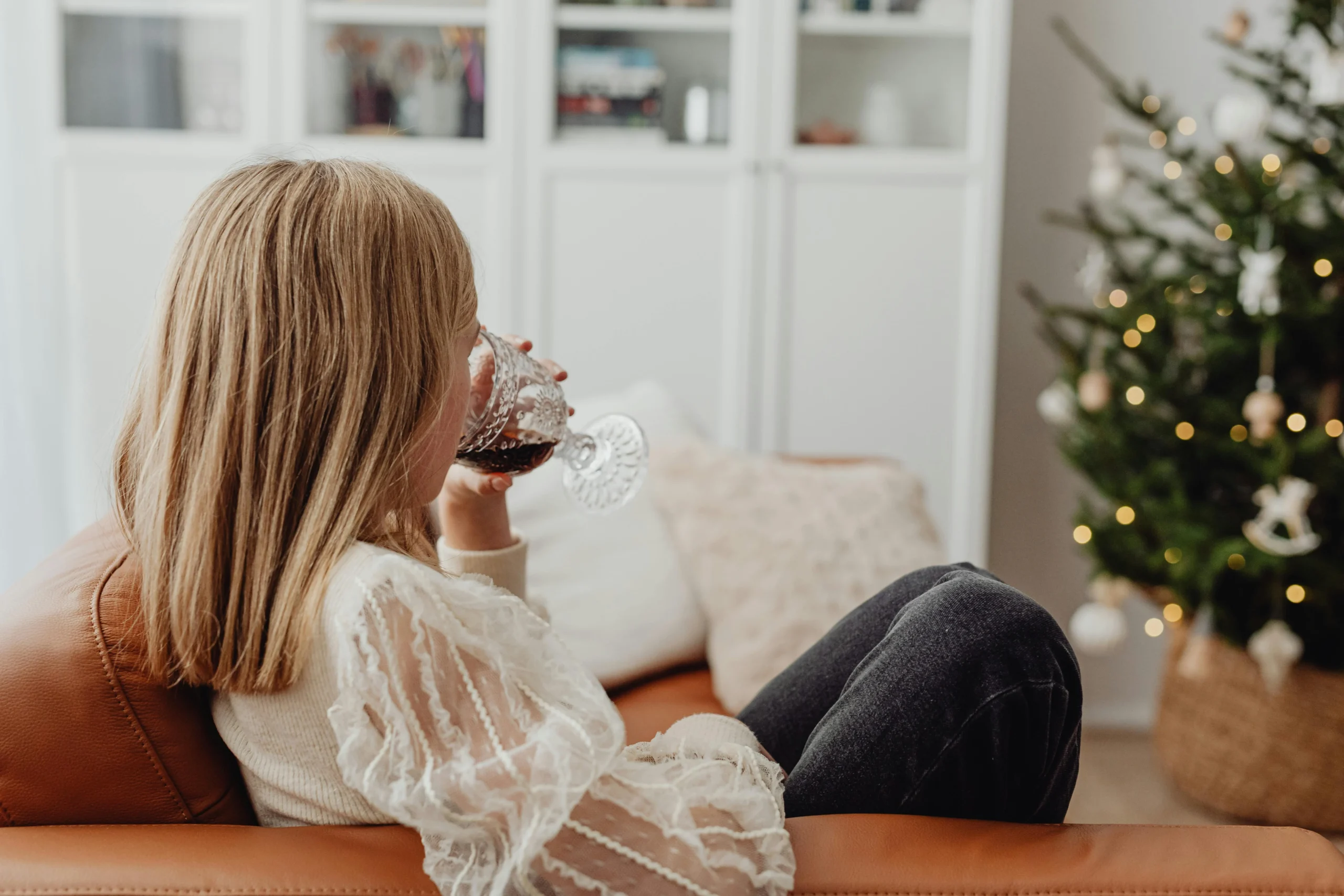 A frustrated woman holding a cup of coffee, showing signs of poor sleep and managing stress during the holidays.